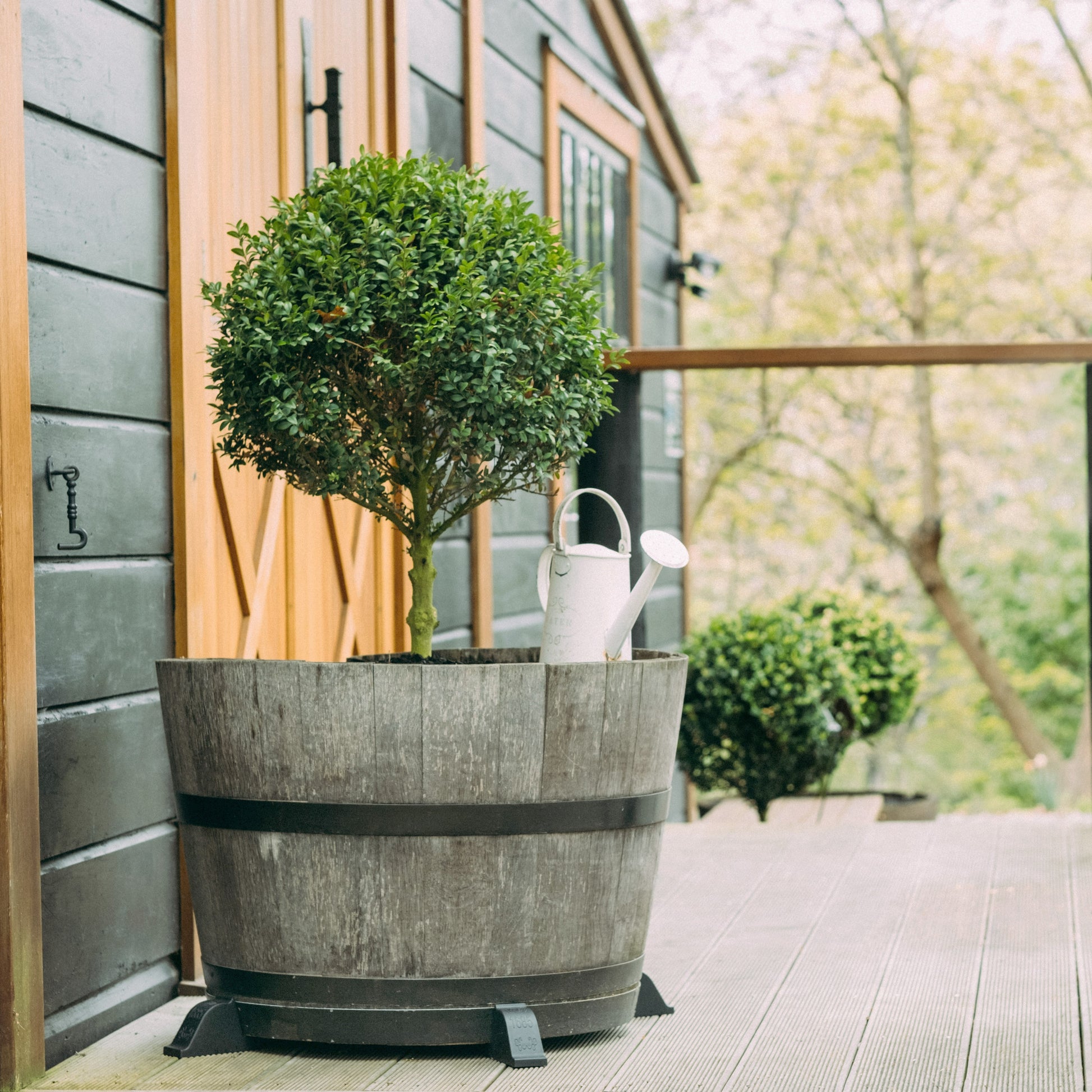 OAKENZ barrel feet lifting half wine barrel planter off wooden deck