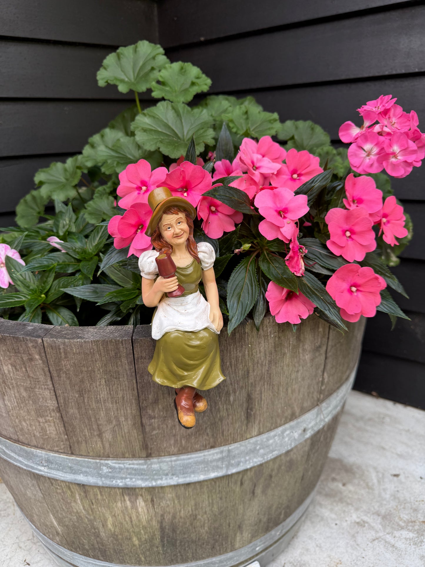 Hand-crafted garden figurine adding character to half barrel planter
