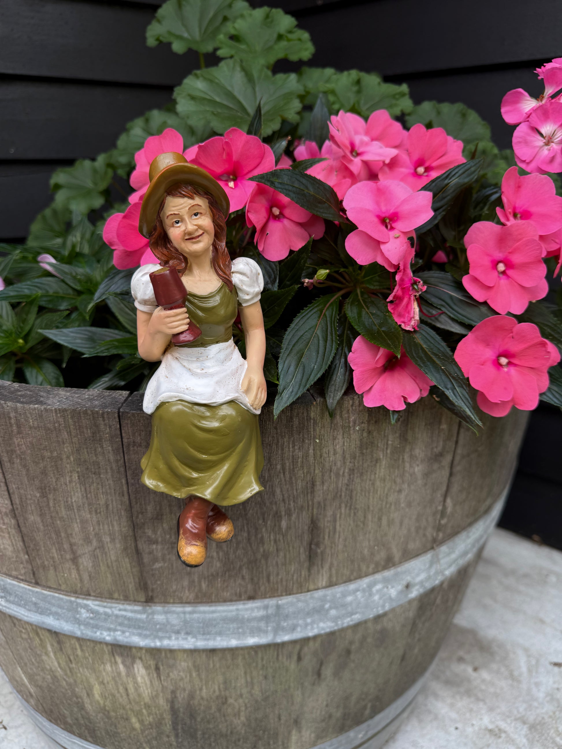 Hand-crafted garden figurine adding character to  wine barrel planter